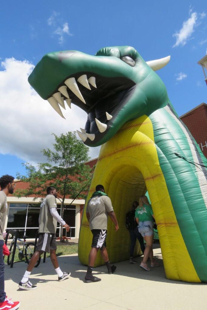 students walking through dragon inflatable